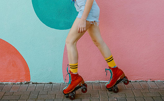 Woman on roller skates in front of colored wall